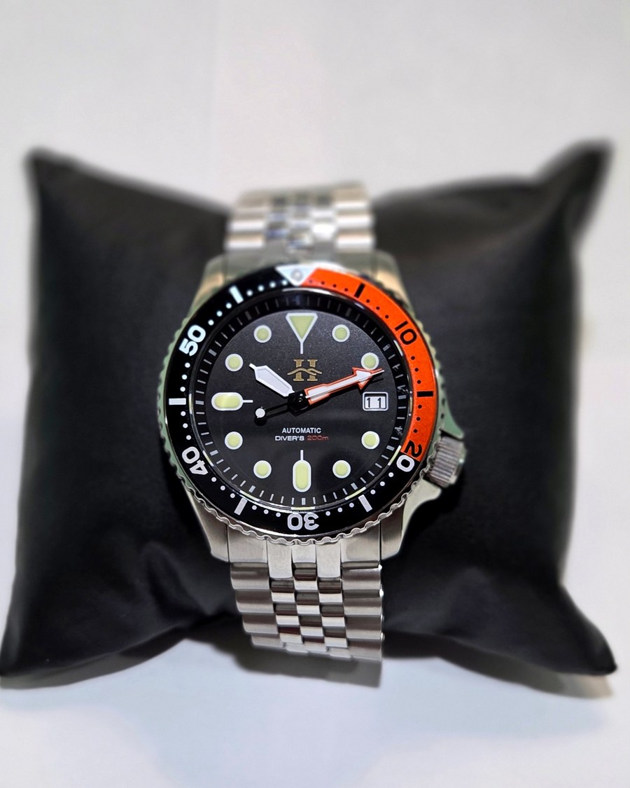Basecamp, a handmade automatic dive watch with an orange and black bezel